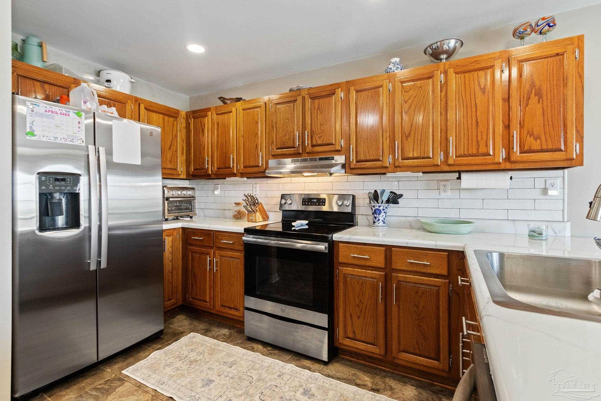 4349 Turkey Hollow Road Frisco City, AL 36445 - Photo 20 of 64 a kitchen with stainless steel appliances granite countertop a refrigerator a sink a stove and cabinets