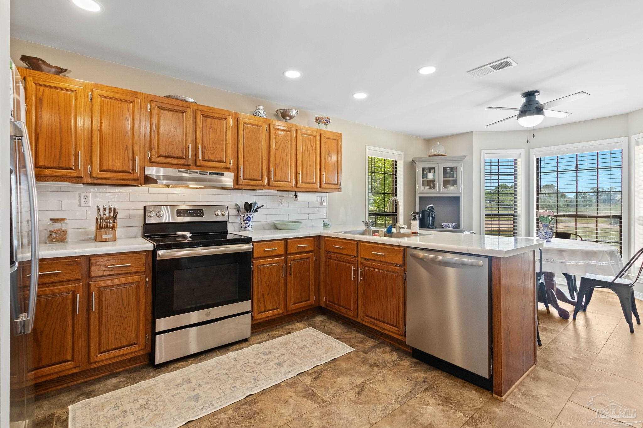 4349 Turkey Hollow Road Frisco City, AL 36445 - Photo 3 of 64 a kitchen with stainless steel appliances granite countertop wooden cabinets a sink and a stove