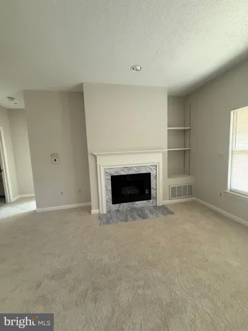a view of empty room with a fireplace