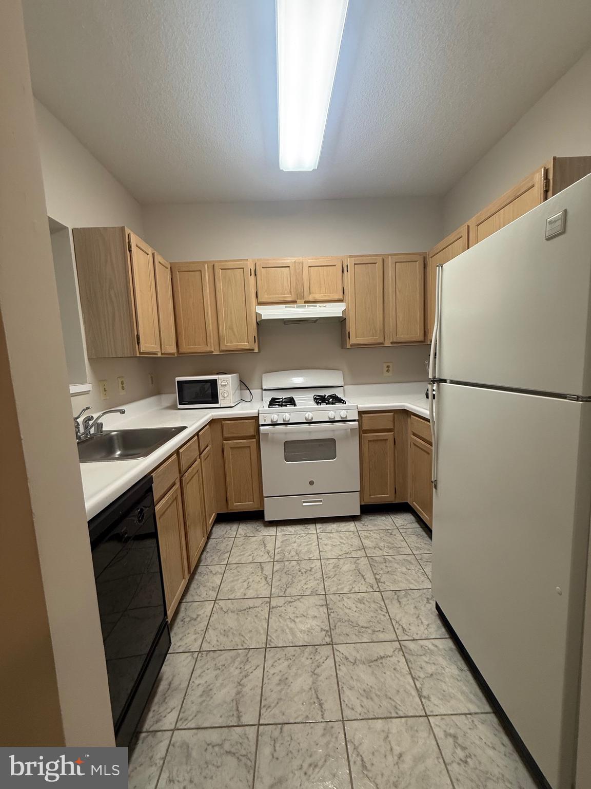 12012 Taliesin Place, Unit 24 Reston, VA 20190 - Photo 4 of 21 a kitchen with a sink a white cabinets and white appliances
