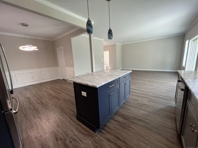 a kitchen with stainless steel appliances granite countertop wooden cabinets a sink a window and wooden floor