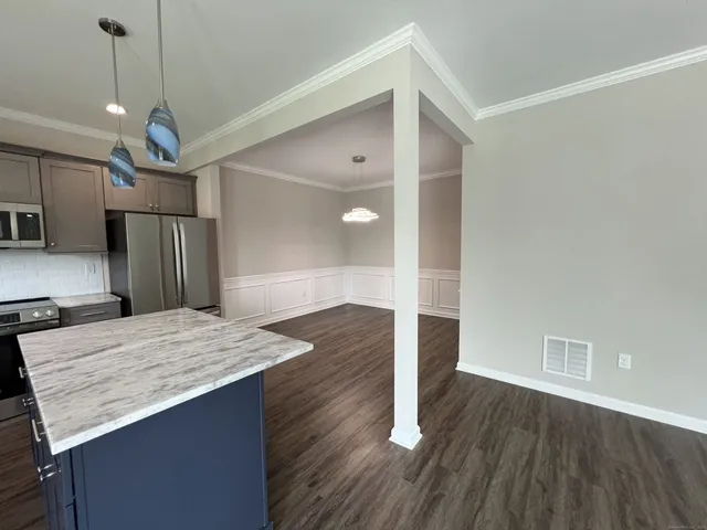 a open kitchen with a refrigerator a sink and wooden floor