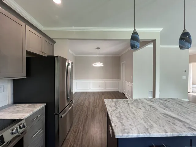 a kitchen with kitchen island a counter top space wooden floor and appliances