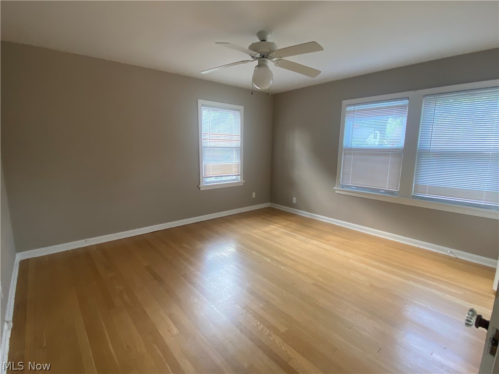 4218 Silsby Road University Heights, OH 44118 - Photo 15 of 27 Light wood-finish flooring with a neutral wall color, featuring two windows and a ceiling fan