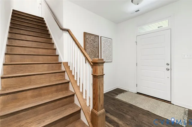 a view of entryway and gallery with wooden floor