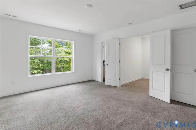 an empty room with windows and closet