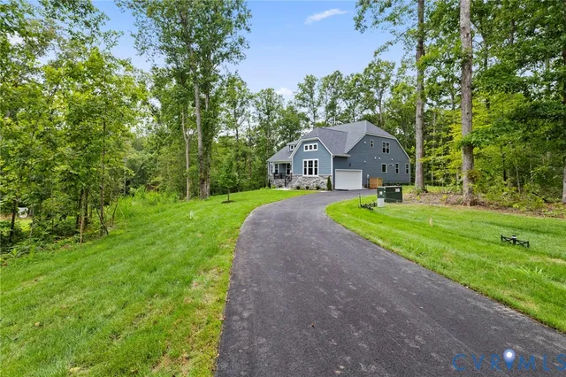 a front view of a house with a yard and trees