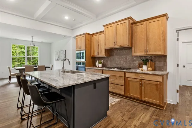 a kitchen with granite countertop a table chairs sink and cabinets