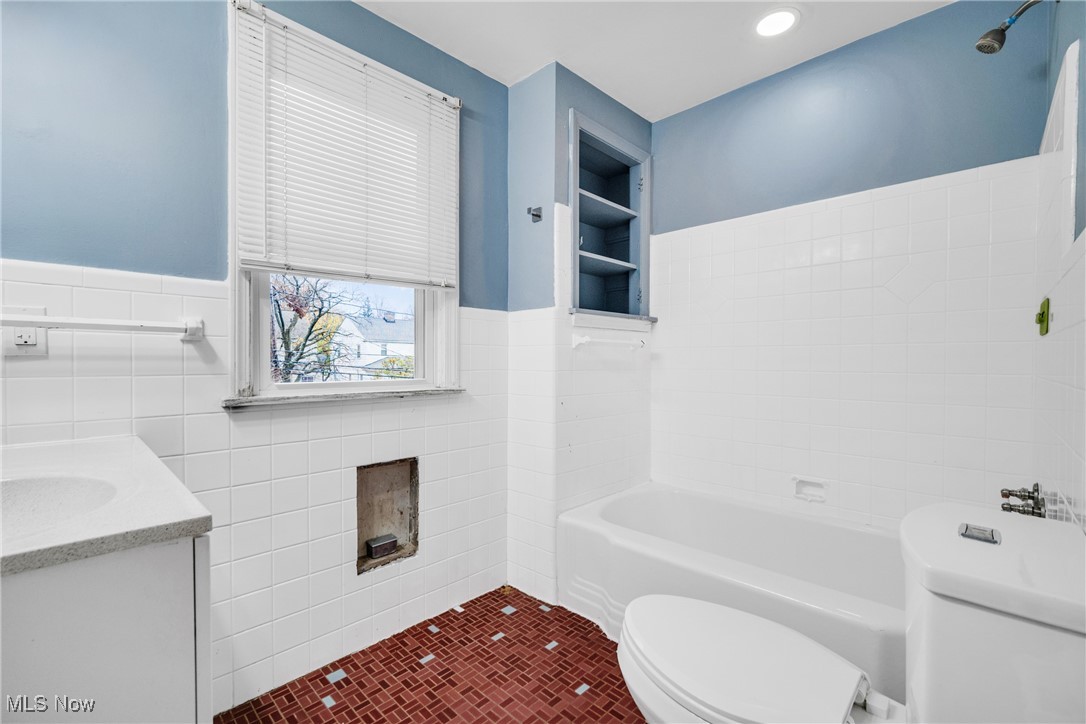 4430 Silsby Road Cleveland, OH 44118 - Photo 25 of 43 Bathroom with tile patterned flooring, toilet, a bathtub, vanity, and tile walls