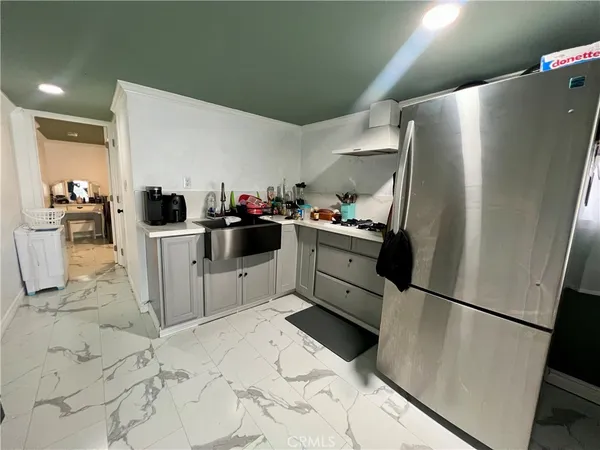 a kitchen with a sink a refrigerator and cabinets