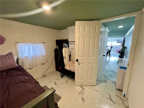 a view of a hallway to room with furniture and wooden floor