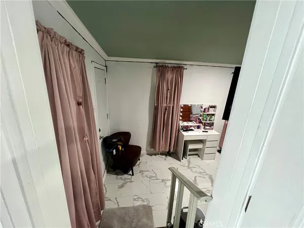 a view of a hallway and a livingroom with furniture