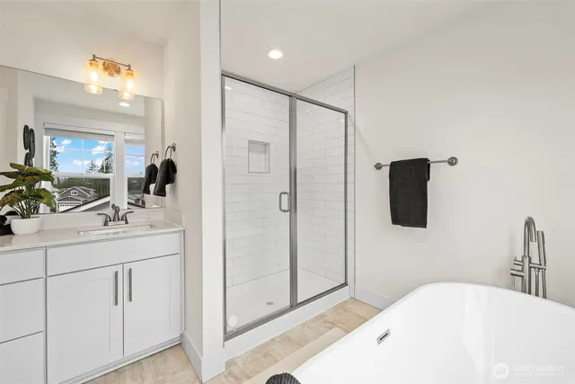 a bathroom with a tub sink and mirror