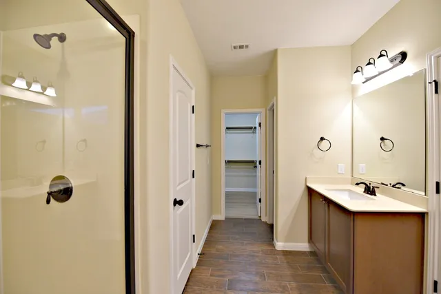 a bathroom with a double vanity sink mirror and shower