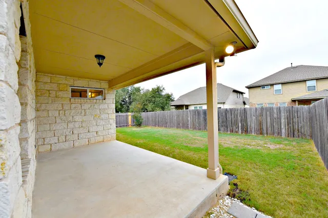a view of a backyard with wooden fence