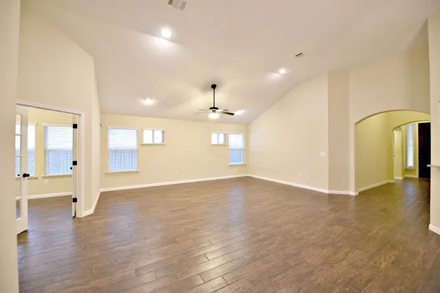 a view of an empty room and a kitchen with a sink windows