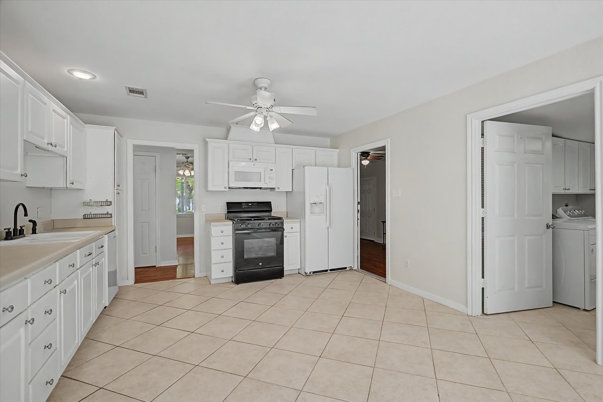 413 Farrer Street Angleton, TX 77515 - Photo 11 of 43 a large white kitchen with cabinets a washer and dryer