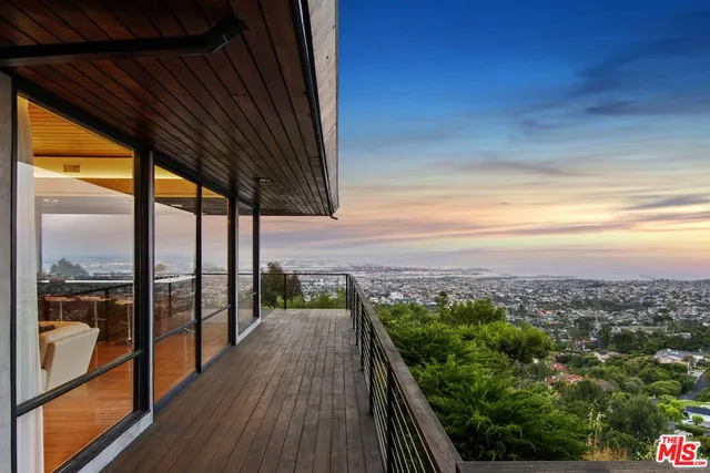 a view of a house with potted plants next to a road