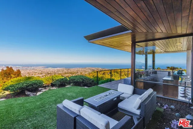 a view of a chair and table in backyard of the house