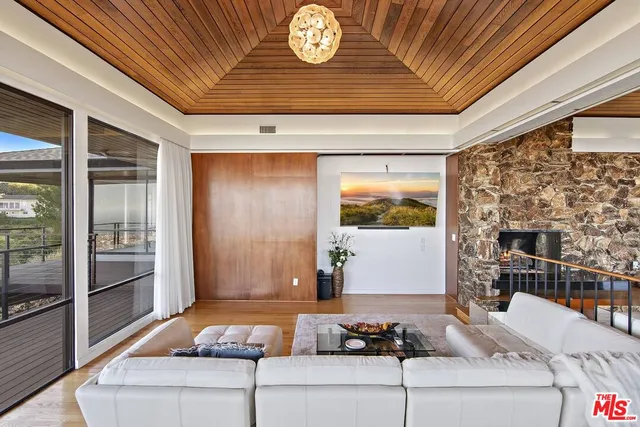 a dining hall with stainless steel appliances granite countertop a stove and chairs with wooden floor