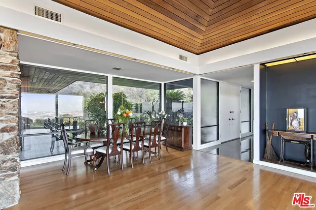 a view of a living room with a floor to ceiling window and wooden floor
