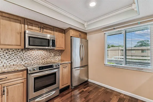 a kitchen with stainless steel appliances granite countertop a stove and cabinets