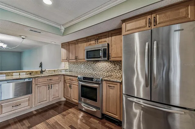 a kitchen with stainless steel appliances granite countertop a stove microwave and cabinets