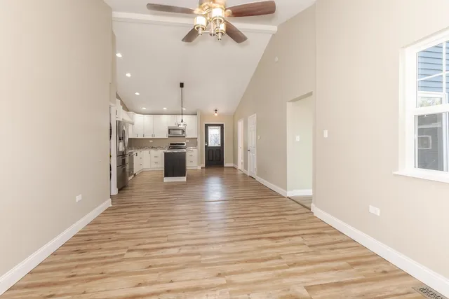 a view of a living room a kitchen with a wooden floor