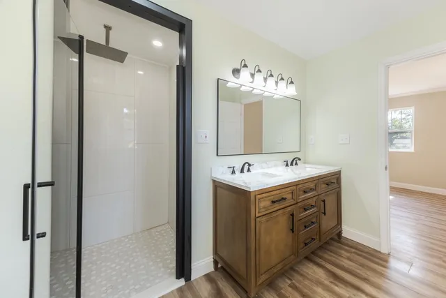 a bathroom with a sink mirror and a shower