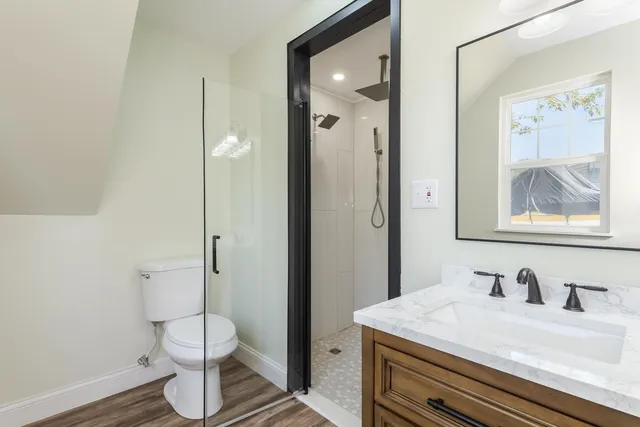 a bathroom with a granite countertop sink toilet and a mirror