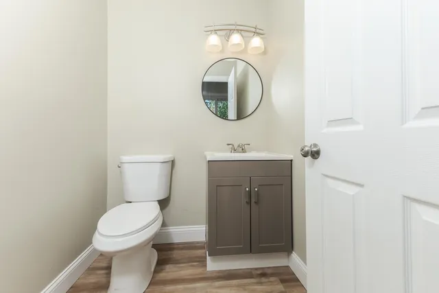 a bathroom with a toilet sink vanity and mirror