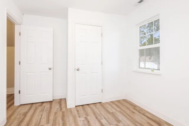 a view of a room with wooden floor and a window
