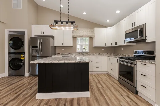 a kitchen with stainless steel appliances granite countertop a stove and cabinets