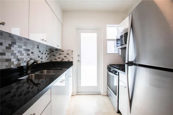 a kitchen with granite countertop a refrigerator and a stove