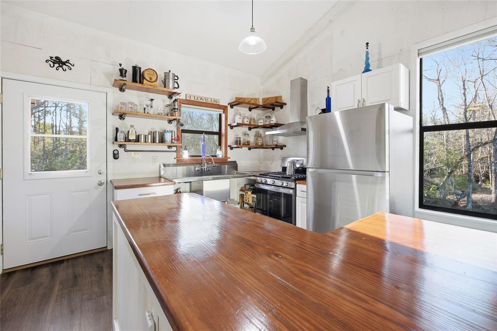 0 Clayton Road Cedar Key, FL 32625 - Photo 8 of 22 a kitchen with stainless steel appliances wooden floors and refrigerator