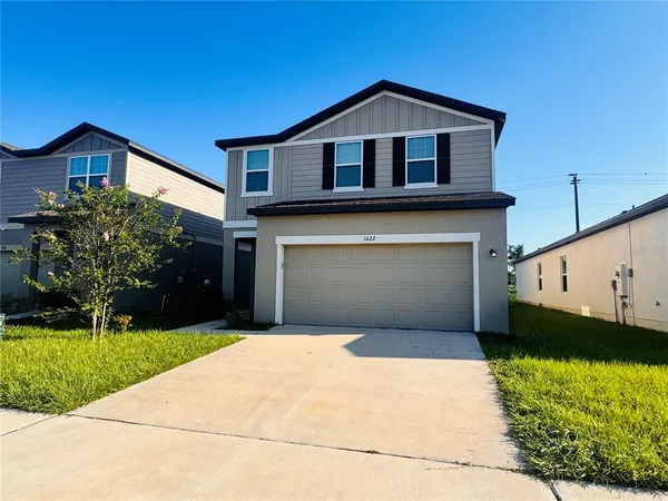 a front view of a house with a yard and garage