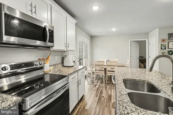 a kitchen with stainless steel appliances kitchen island granite countertop a sink and a stove