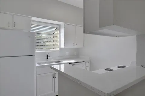 a kitchen with a sink cabinets and a refrigerator