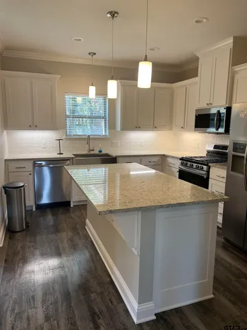a kitchen with stainless steel appliances granite countertop a stove and a microwave