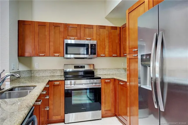 a kitchen with stainless steel appliances a stove microwave and sink