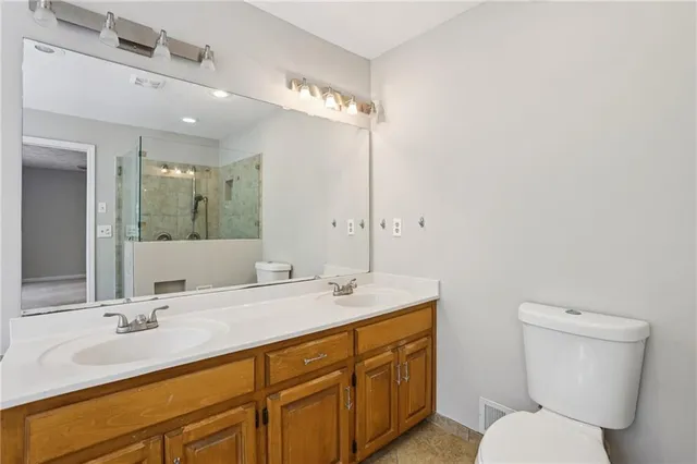 a bathroom with a granite countertop sink mirror and toilet