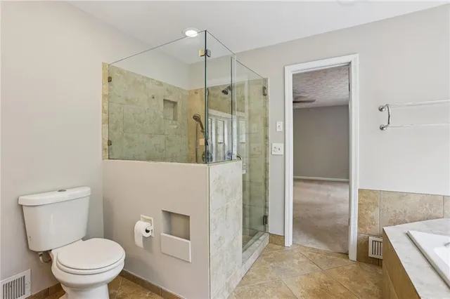 a bathroom with a toilet a sink and shower