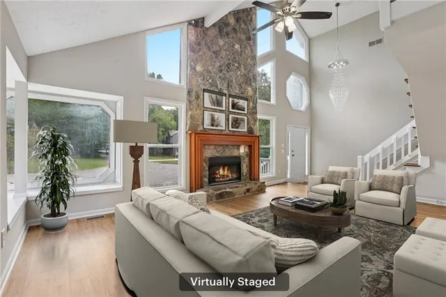 a living room with furniture a large window and a fireplace