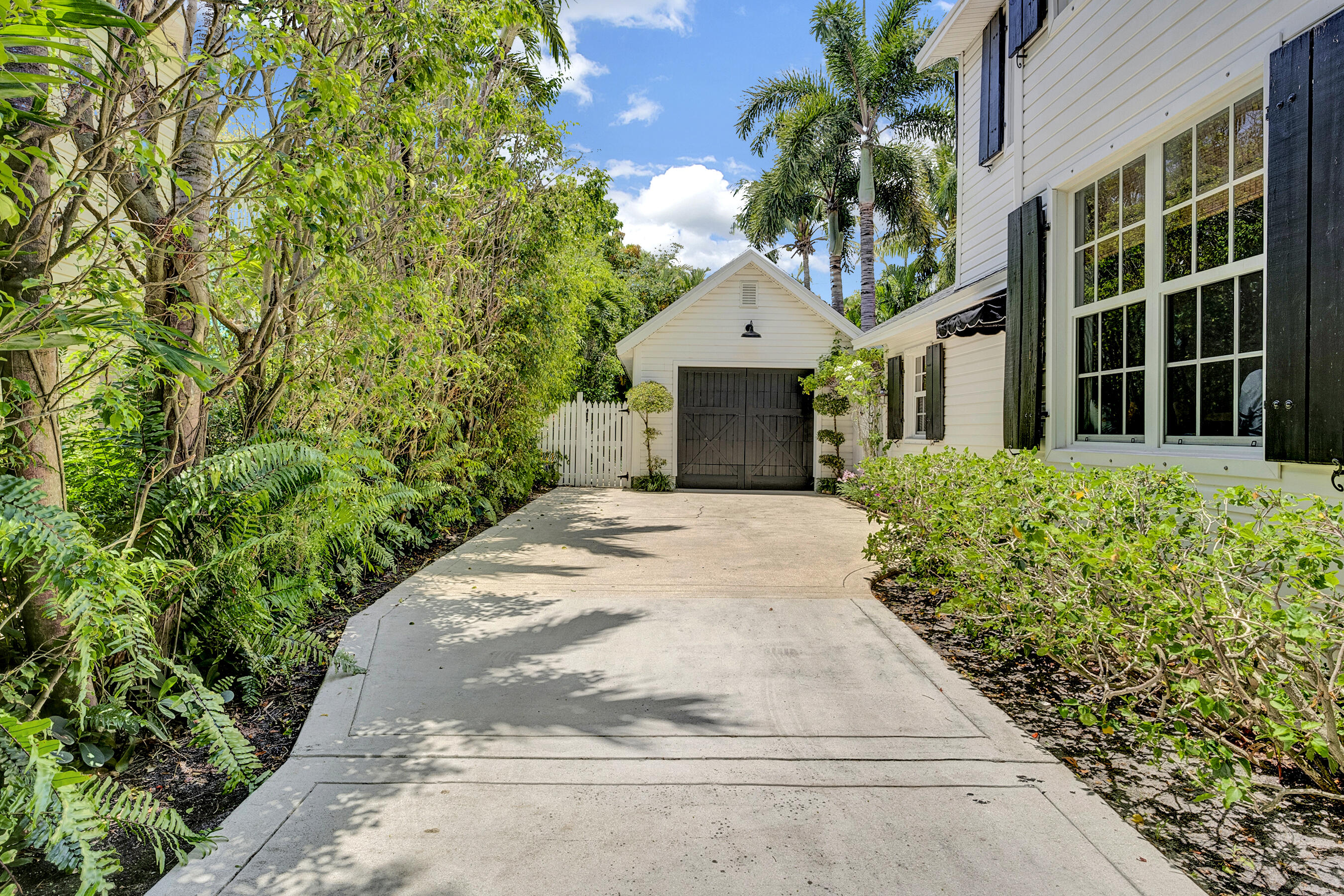 306 North Swinton Avenue Delray Beach, FL 33444 - Photo 17 of 53 a front view of a house with a garden