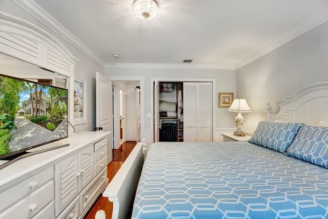 a bedroom with a bed and a dresser next to a window