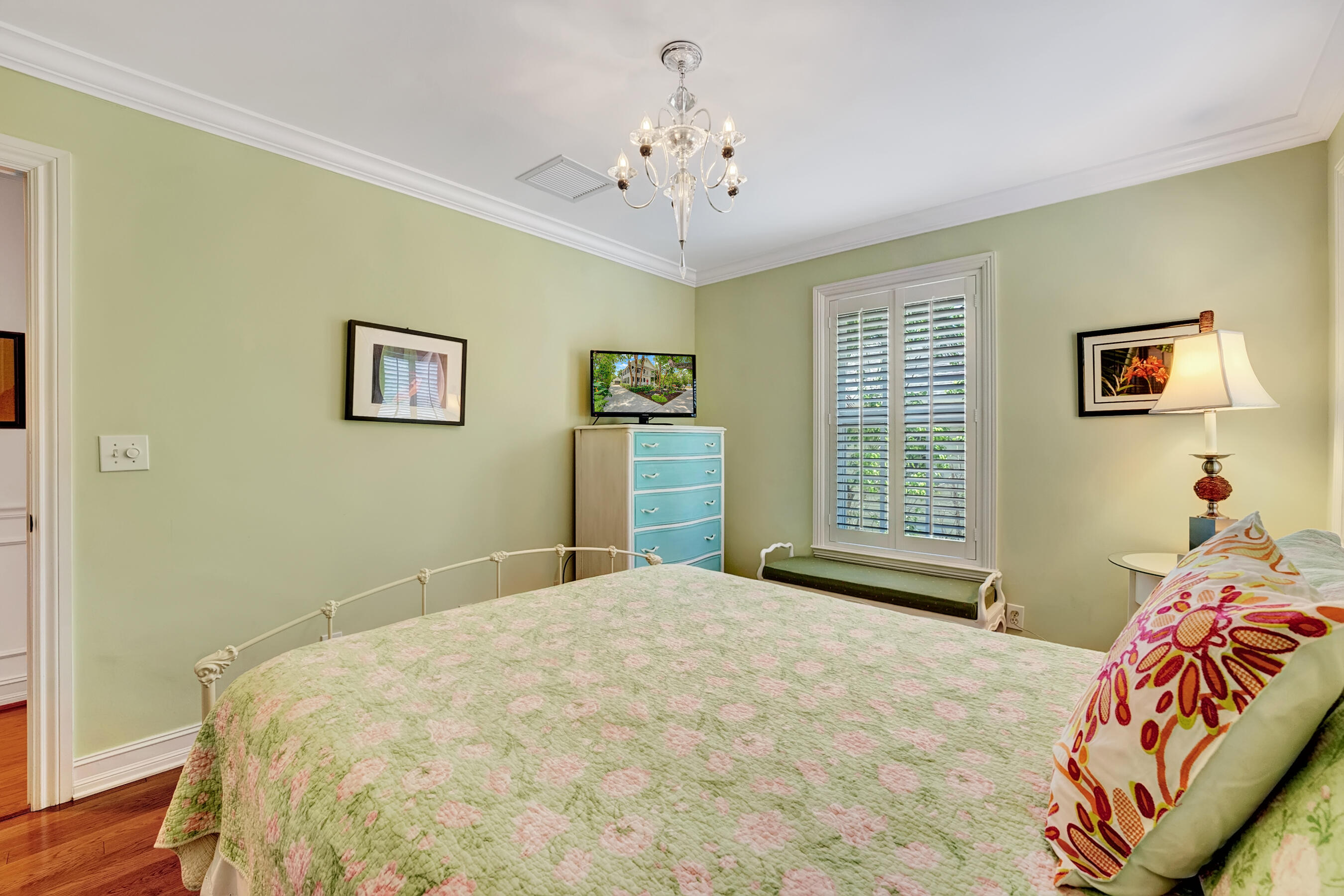306 North Swinton Avenue Delray Beach, FL 33444 - Photo 23 of 53 a bedroom with a large bed and a chandelier
