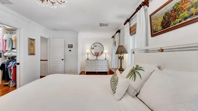 a bedroom with a bed and a flat tv screen on dresser