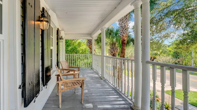 a view of a balcony with chairs and floor to ceiling window