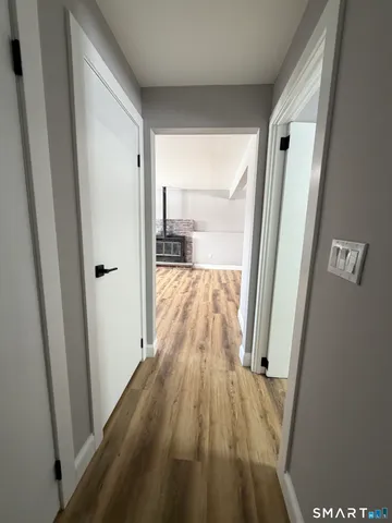 a view of a hallway with wooden floor and staircase