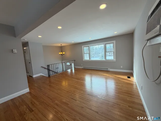 a view of a livingroom with wooden floor and a window